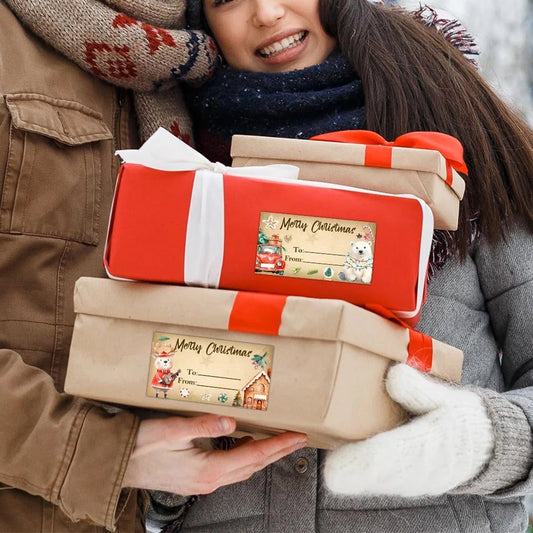 Person holding two wrapped Christmas presents with festive labels.