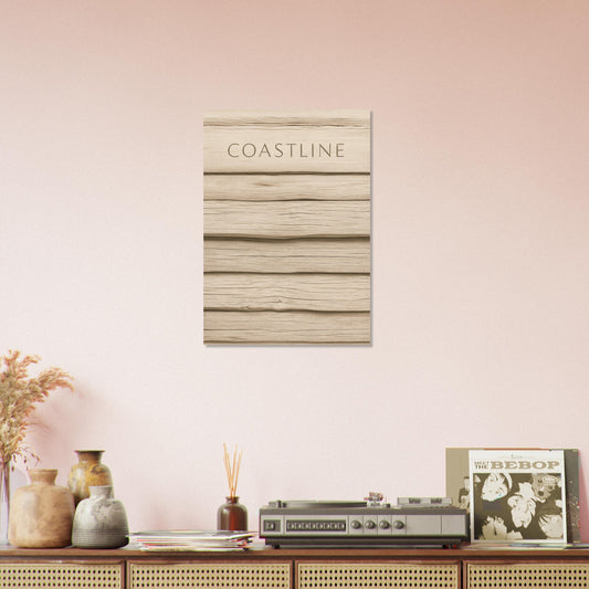 Coastline poster with driftwood texture hanging on a blush pink wall above a vintage sideboard with vinyl records and decor