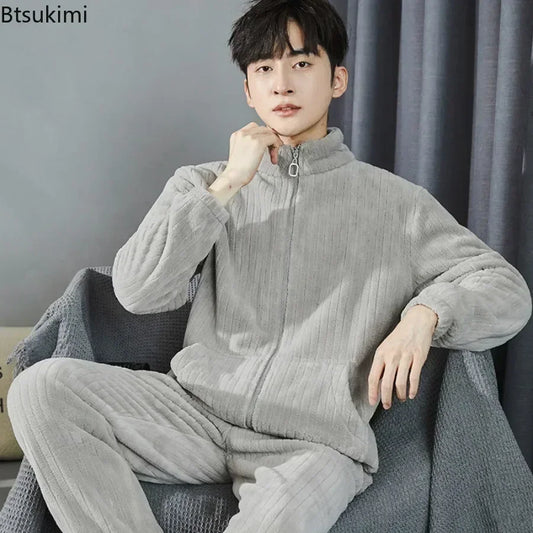 Person wearing a gray fleece tracksuit sitting on a couch with a plain background