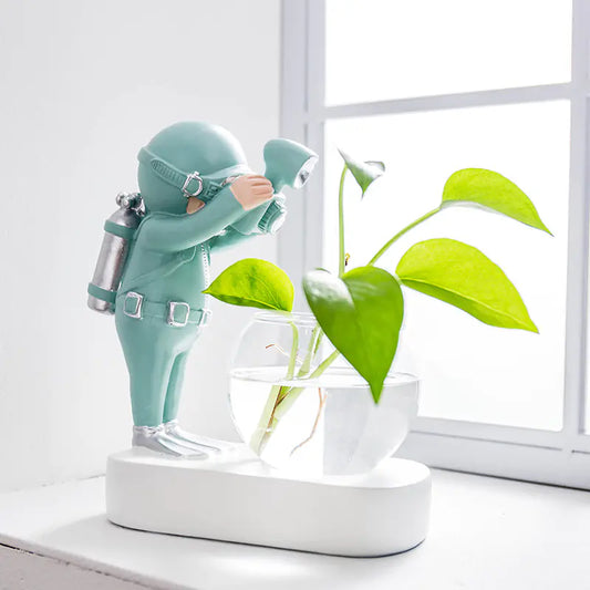 Decorative figure of an astronaut with a plant on a white surface