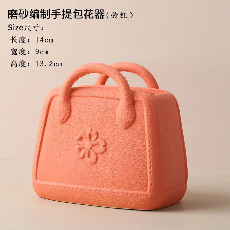 Pink handbag-shaped flower pot with size specifications on a beige background