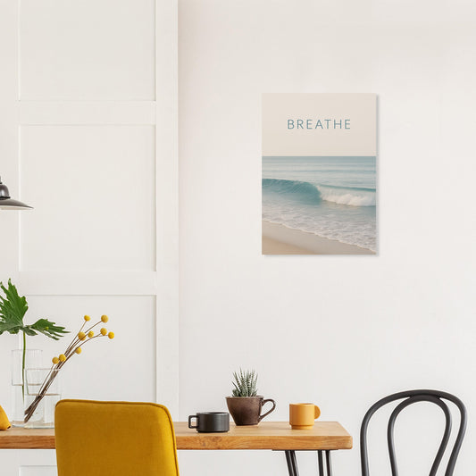 BREATHE ocean wave poster displayed above a dining table in a modern, minimalist room with yellow chair and plant décor