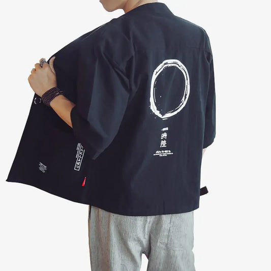 Person wearing a dark blue kimono with white designs on a plain background