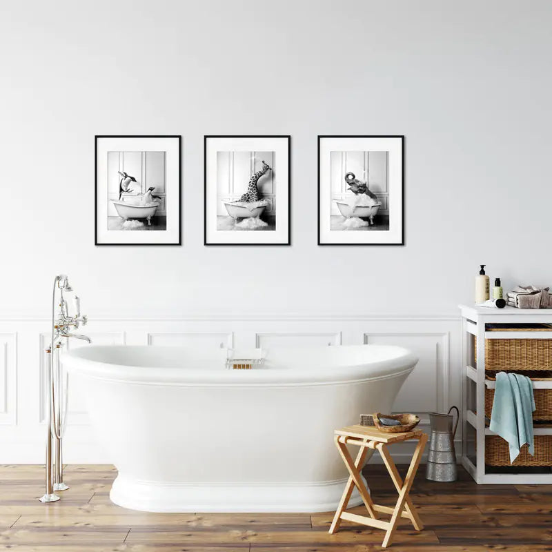 Bathroom interior with a freestanding bathtub, wooden stool, and framed black and white photos on the wall.