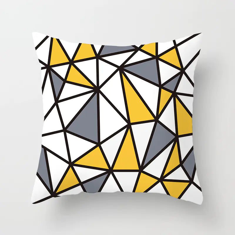 Geometric patterned pillow with yellow, gray, and black triangles on a white background