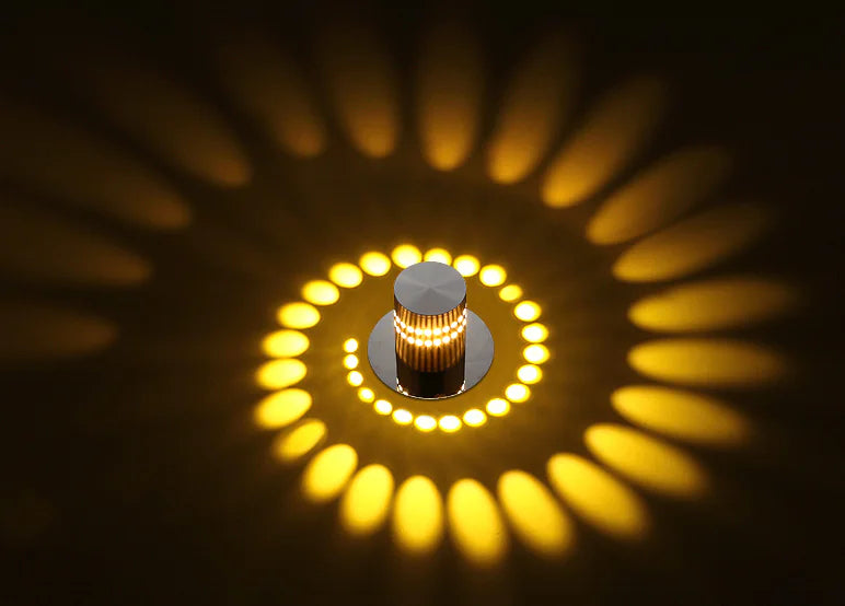 Close-up of a light fixture with glowing yellow circular pattern on a dark background