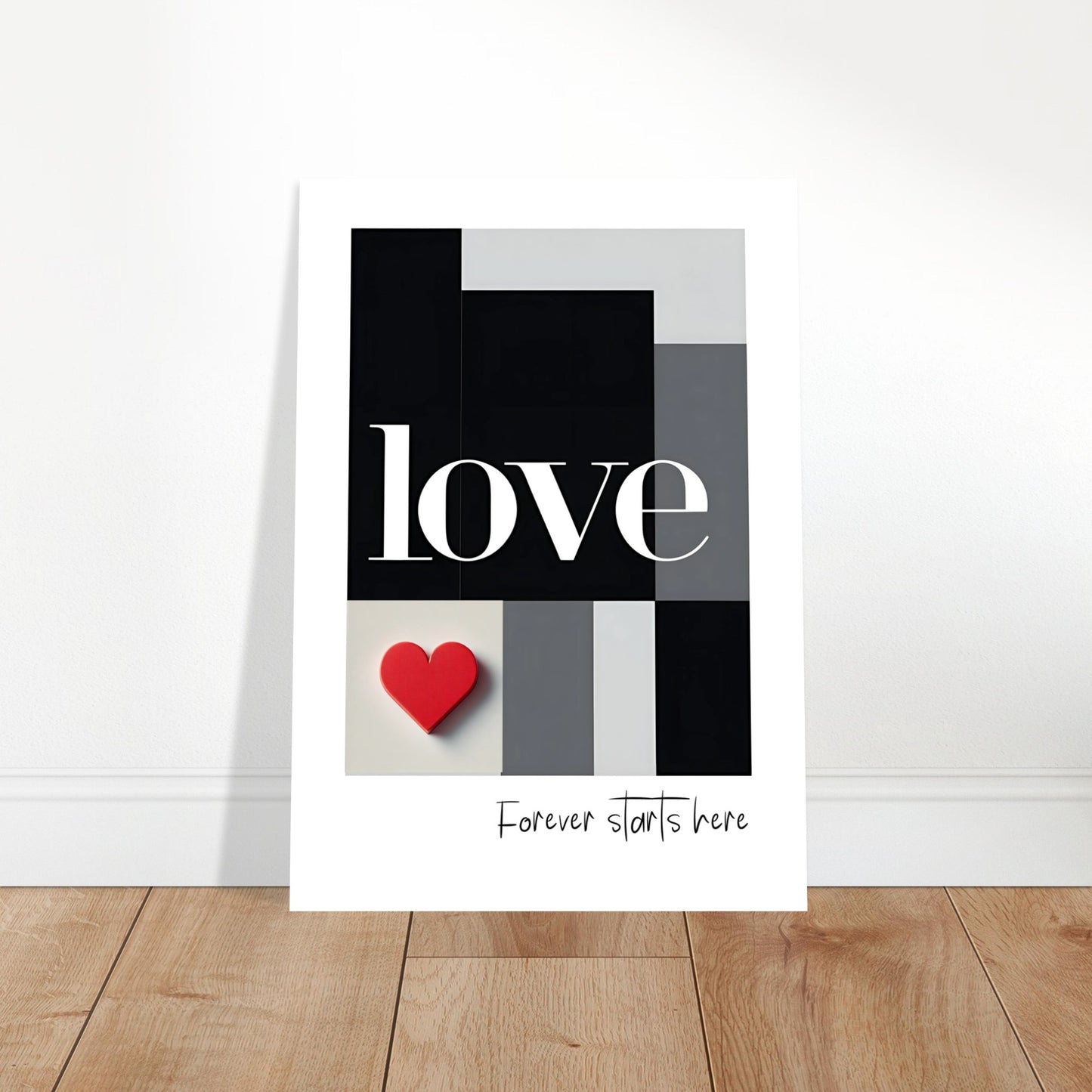 Minimalist black and white love typography poster leaning against wall on wooden floor, romantic and modern design.