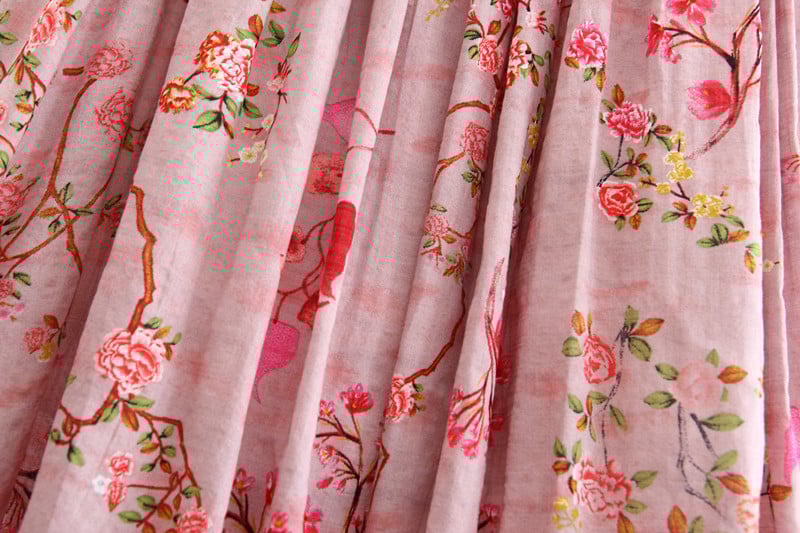 Floral patterned fabric with pink and red flowers on a light background