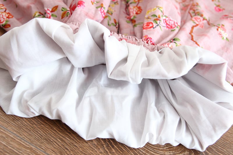 White pet bed with floral fabric in the background