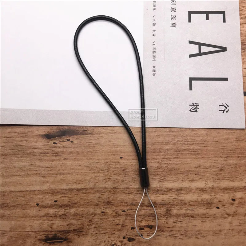 Black lanyard on a wooden surface with a white paper background