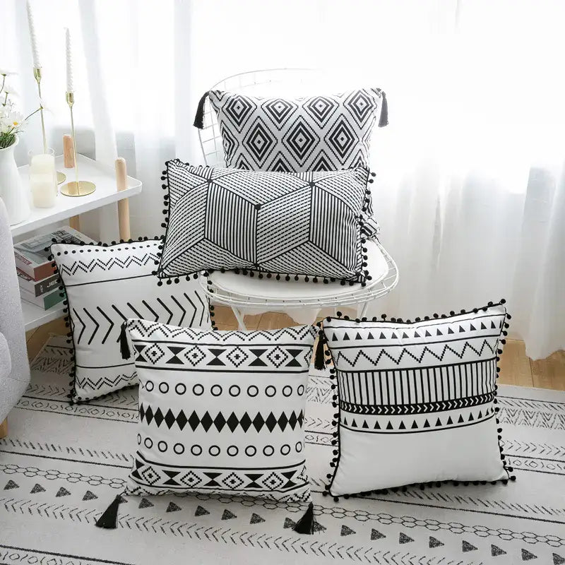 Set of Nordic minimalist cushion covers featuring abstract and geometric designs, displayed together on a neutral-toned chair