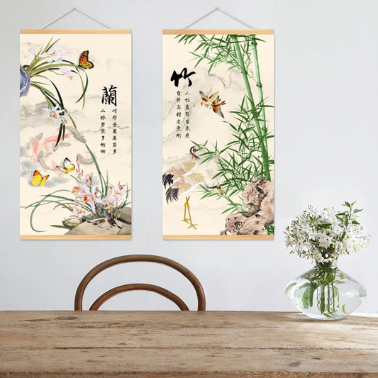 Two framed artworks with nature-themed designs on a wall above a wooden table.