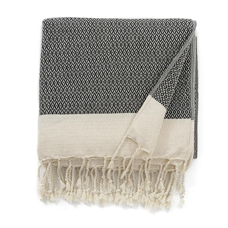 Black and white patterned blanket with frayed edges on a white background
