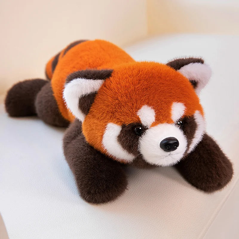 Plush toy red panda lying on a light surface