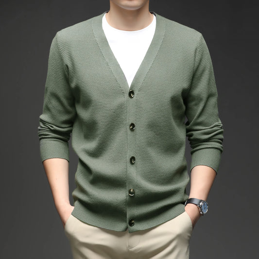 Green cardigan worn by a person on a dark background