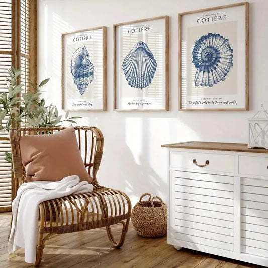 Nautical-themed room with framed shell prints, a wicker chair, and a white cabinet.