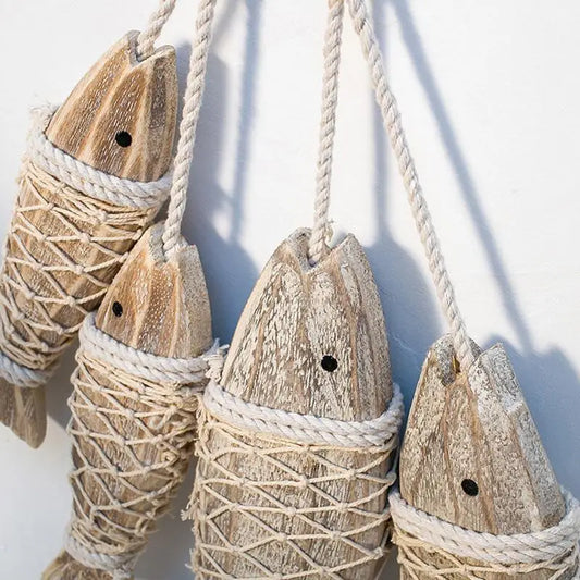 Wooden fish-shaped ornaments with rope against a white background