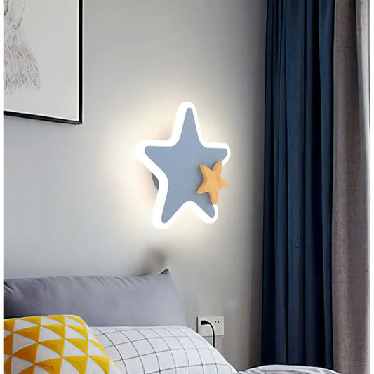 Star-shaped LED wall light in a bedroom setting with a gray wall, blue curtain, and gray bed.