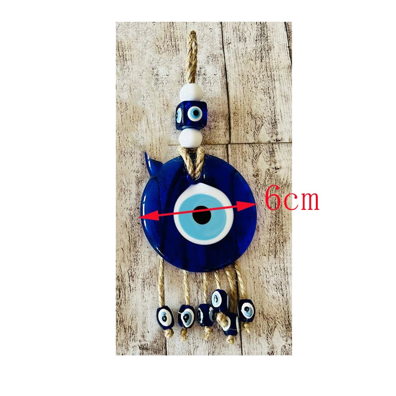 Decorative evil eye charm with beads on a wooden background, size indicated as 6cm.