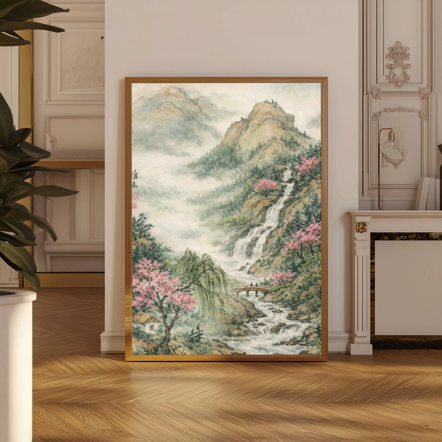 Framed artwork of a mountain landscape with a waterfall in a room with wooden flooring and decorative elements.