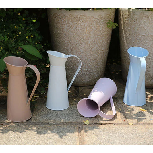 Set of colorful vase jugs on a stone surface with decorative pots in the background