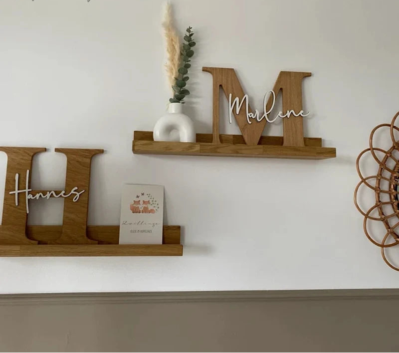 Wooden shelves with decorative letters and a vase on a white wall.