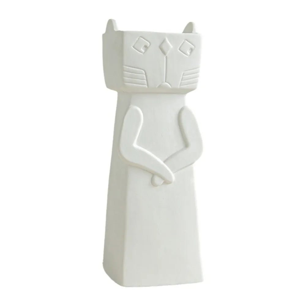 A minimalist white ceramic cat figurine with a stylized, geometric design, standing against a solid white background.