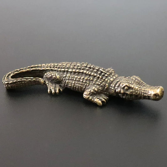 Bronze alligator figurine on a dark gray background