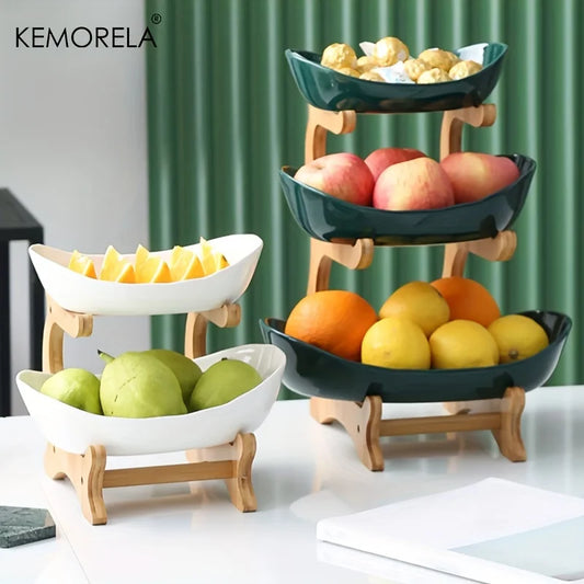 Fruit display stand with various fruits on a white surface and green curtain background