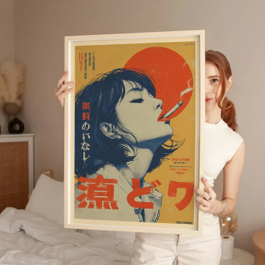 A woman in a white sleeveless top holds up a large framed poster featuring a stylized illustration of a woman with closed eyes, red Japanese text, and a large red sun on a beige background. The room has a neutral beige wall and a bed with white bedding in the background.