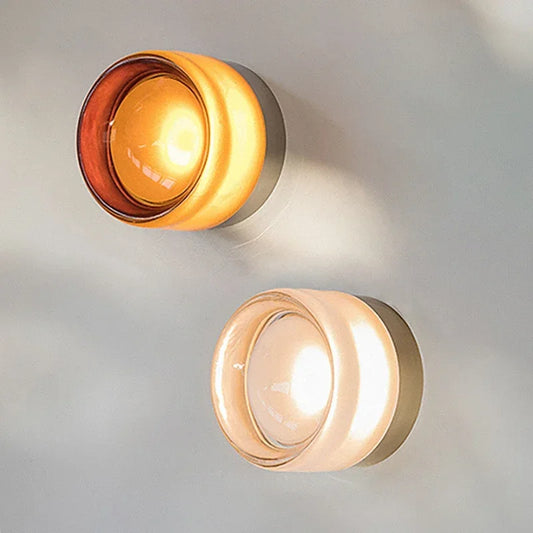 Two round jelly wall lights with a warm glow on a light gray background
