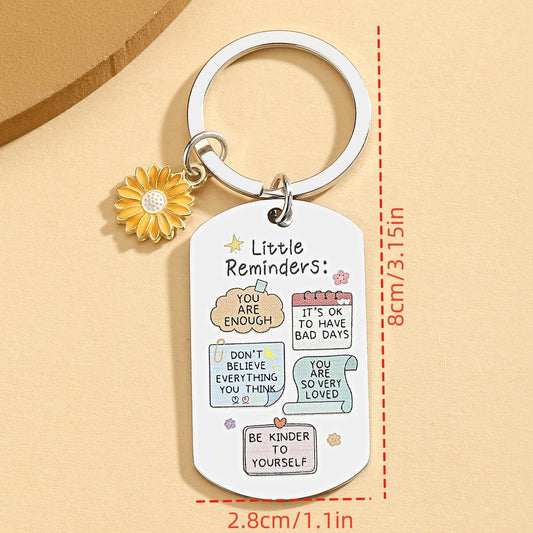 Keychain with motivational phrases and a sunflower charm on a beige background
