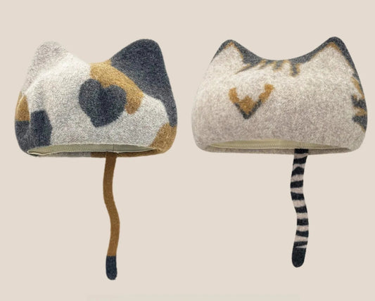 Soft woolly winter hats featuring pointed cat ears in neutral shades and brown patchwork patterns, available in eight colour and design options.