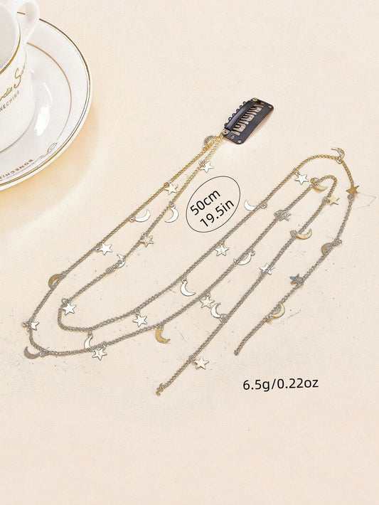 Necklace with star and moon pendants on a beige surface with a teacup in the background.