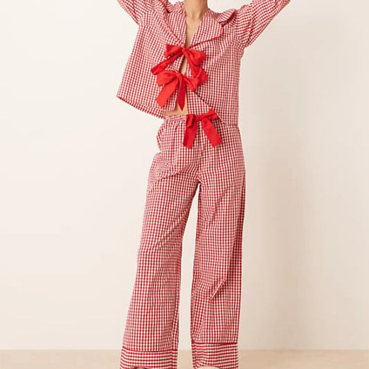 Red gingham pajama set with bow details on a beige background