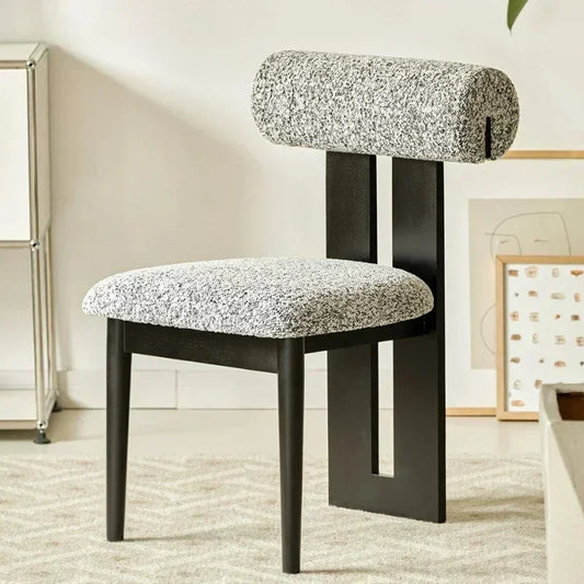 Modern chair with textured gray cushioned seat and backrest in a room setting.