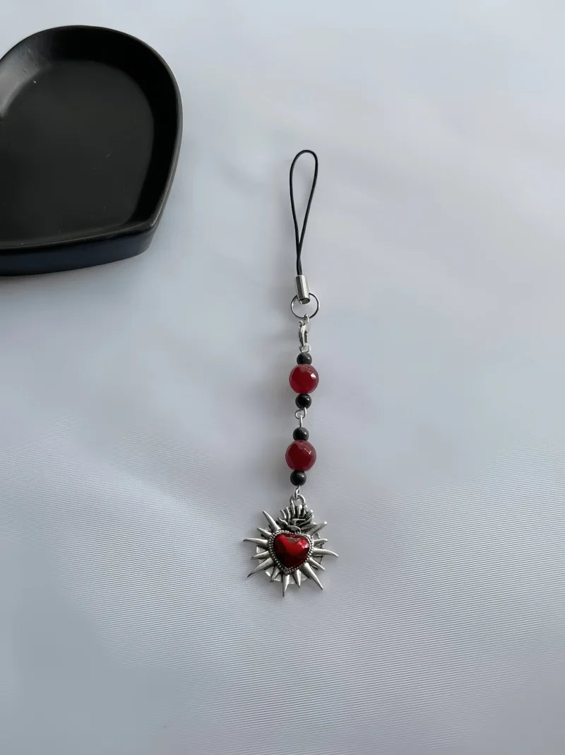 Pendant charm with red heart and beads on a white background