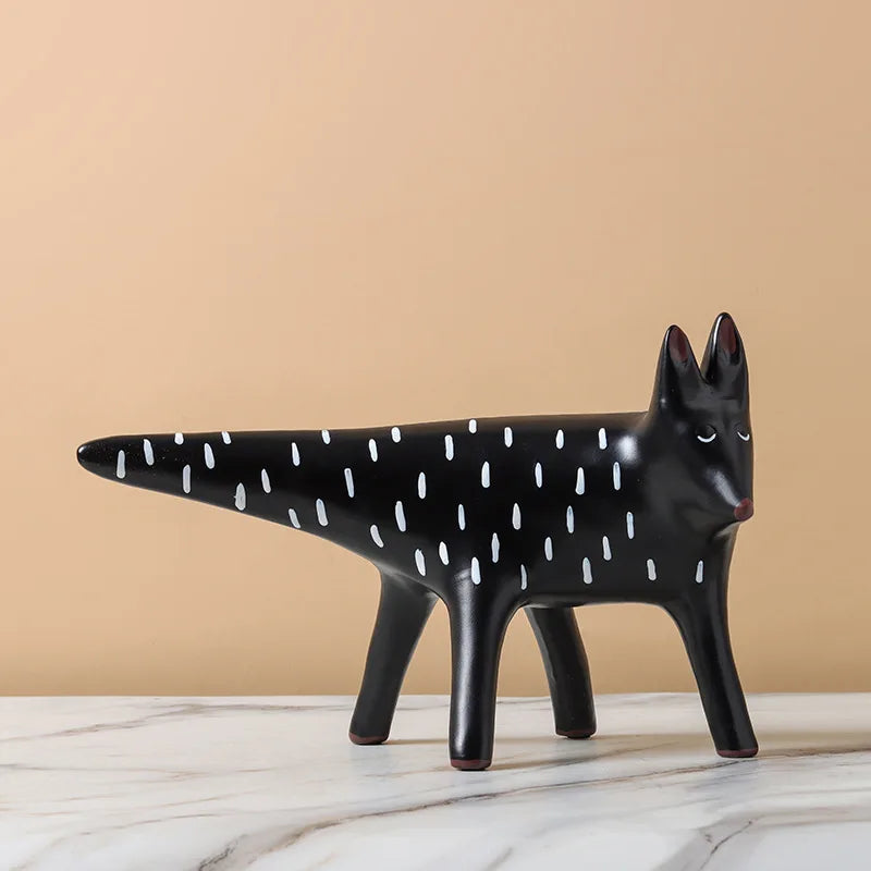 Black ceramic fox figurine with white spots on a beige background