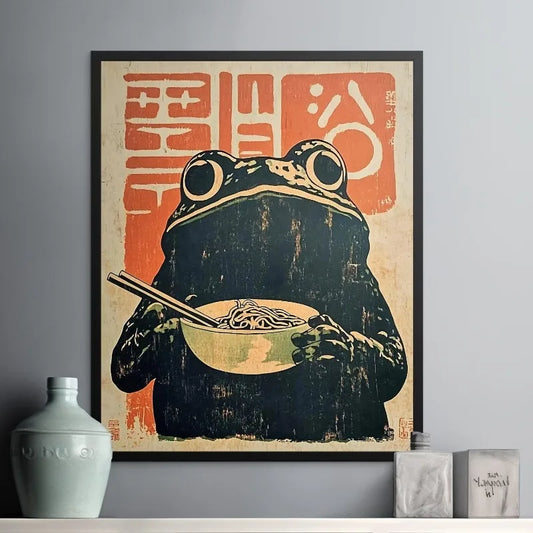 Framed artwork of a frog eating noodles with chopsticks on a textured background.