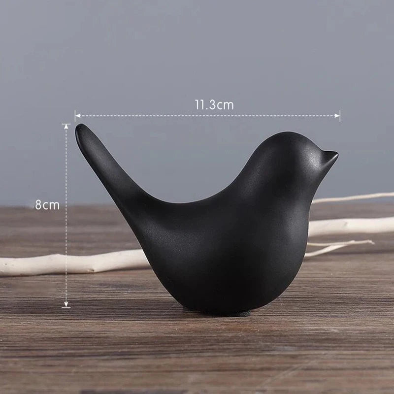 Black bird-shaped object with measurements on a wooden surface and gray background