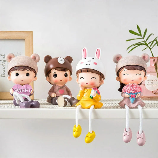 Four cartoon-style figurines with different outfits and accessories on a shelf.