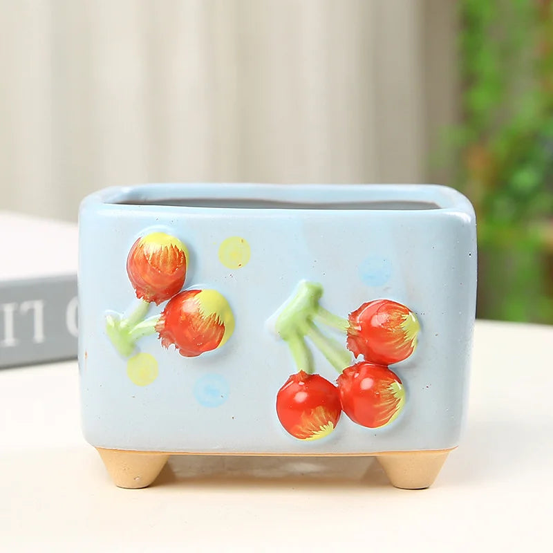 Ceramic planter with cherry design on a light background