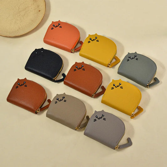Collection of small purses with cat faces in various colors on a beige background