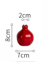 Red ceramic pomegranate with measurements indicated on a white background
