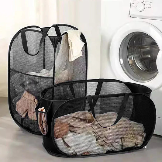 Black mesh laundry baskets with clothes inside, placed in front of a washing machine.