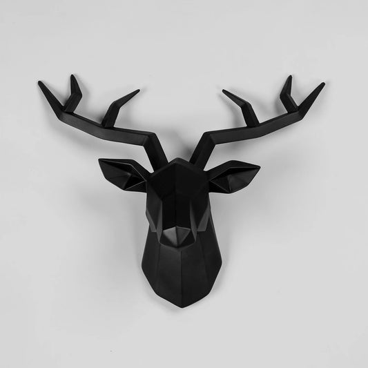 Black deer head wall decoration on a light gray background