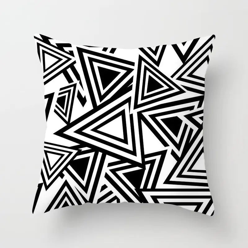 Decorative pillow with black and white geometric triangle pattern on a light gray background