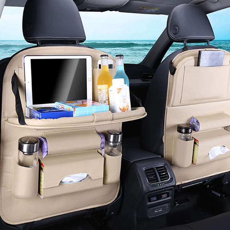 Car back seat organizer with tablet holder, drinks, and snacks on a car seat with ocean view.