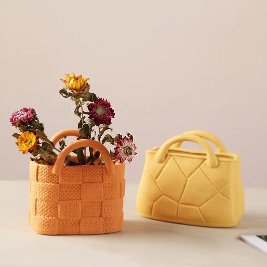 Two Ceramic textured handbags, one with flowers, on a light surface with a neutral background