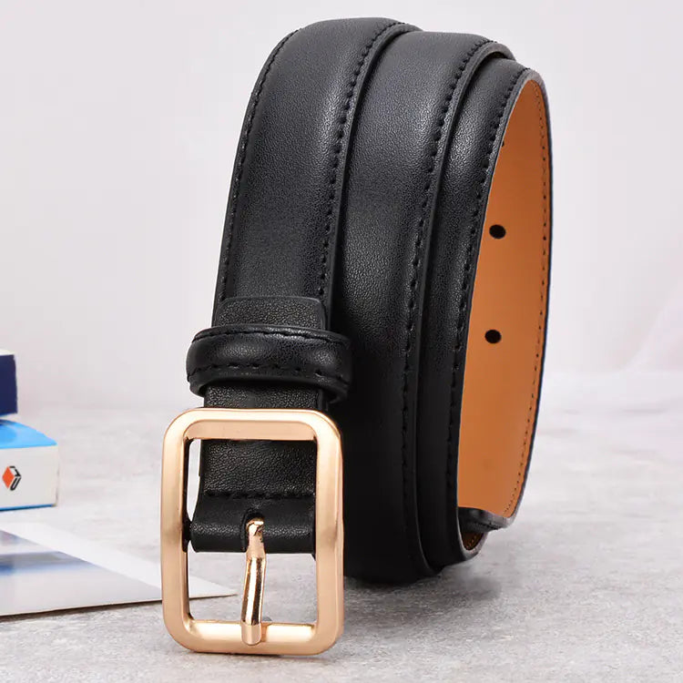 Black leather belt with a gold buckle on a light gray background